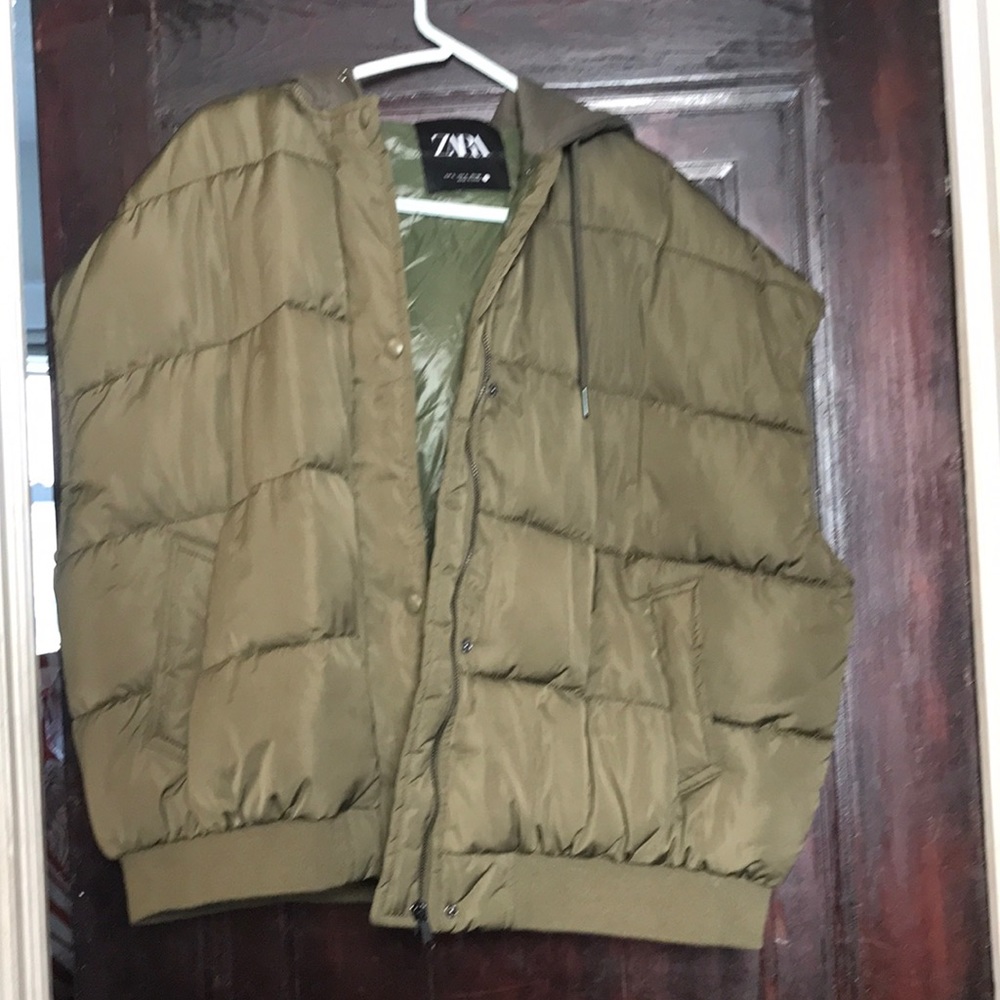 New with tag, khaki colored, quilted puffy vest. It has a drawstring hood.
